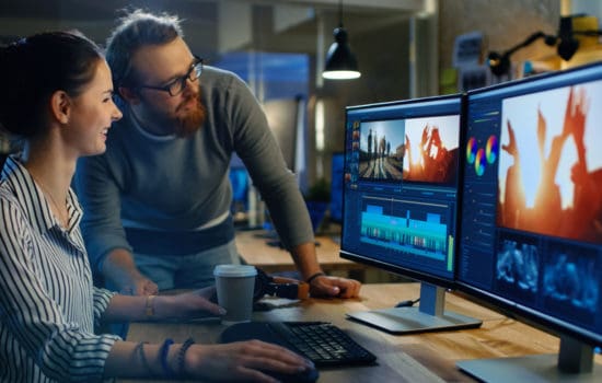 Colorist showing her editing suite to a coworker