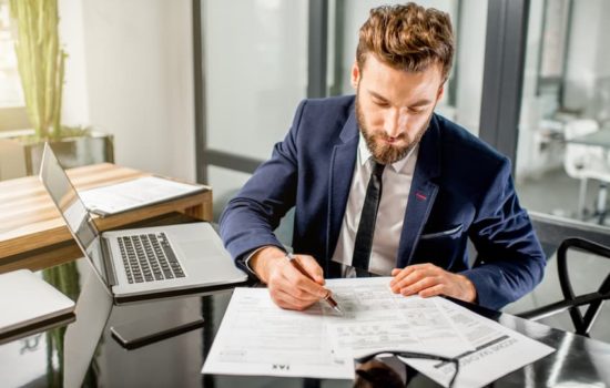 Production Accountant filling out paperwork on his desk