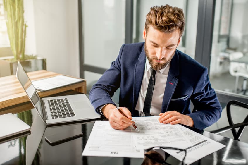 Production Accountant filling out paperwork on his desk