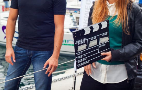 Second AC with crew member carrying film clapper