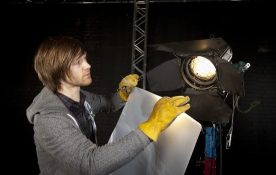 movie story writing Best Boy Grip adjusting lighting on set