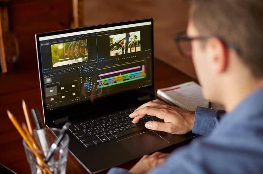 Digital Imaging Technician looking at footage on his laptop