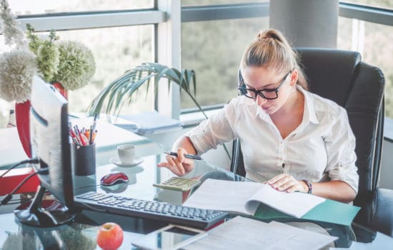 Unit Production Manager looking over paperwork at her desk