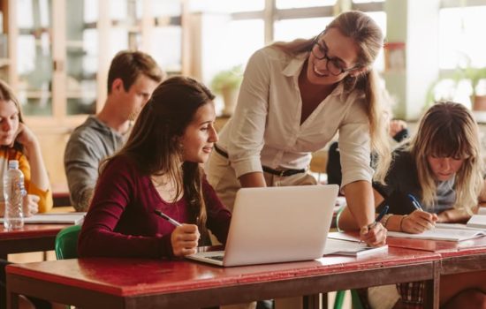 Adjunct professor helping student in the classroom