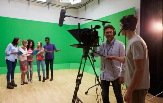 On set visual effects supervisor with camera crew, actors, and green screen
