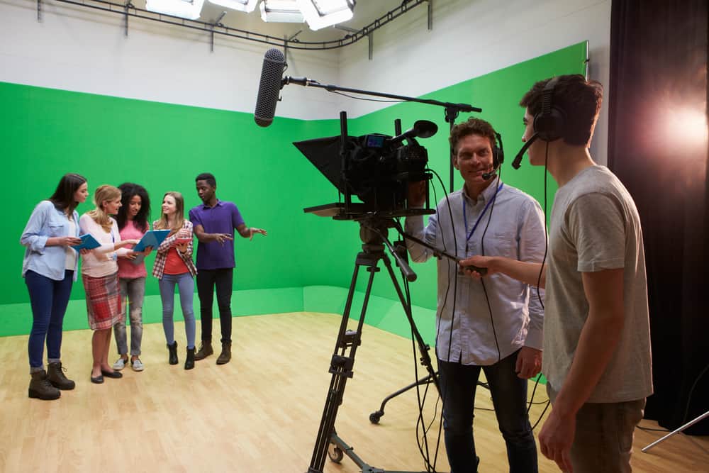 On set visual effects supervisor with camera crew, actors, and green screen