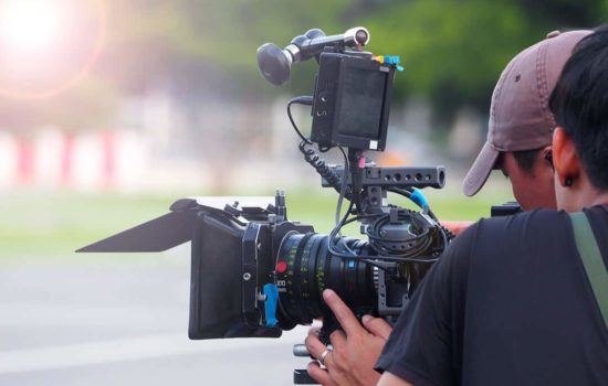 Camera operator looking through film camera