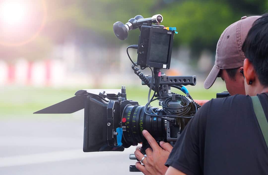 Camera operator looking through film camera