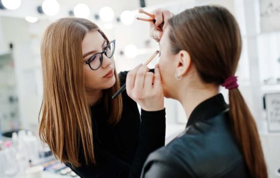 Makeup artist applying eyeshadow on a performer