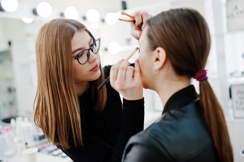 Makeup artist applying eyeshadow on a performer