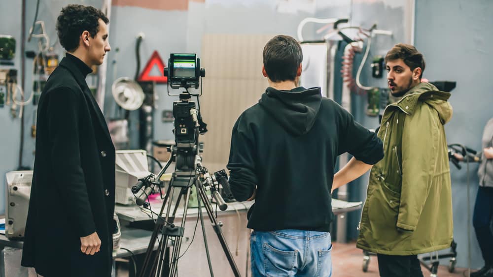 Film producer, director, and camera operator talking on set