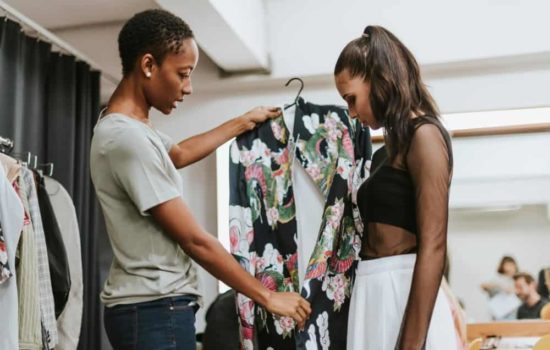Assistant Costume Designer holding up a garment to see if it fits an actress