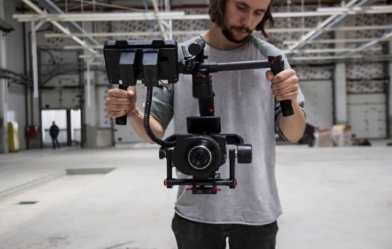 Cameraman looking at his rig on empty soundstage