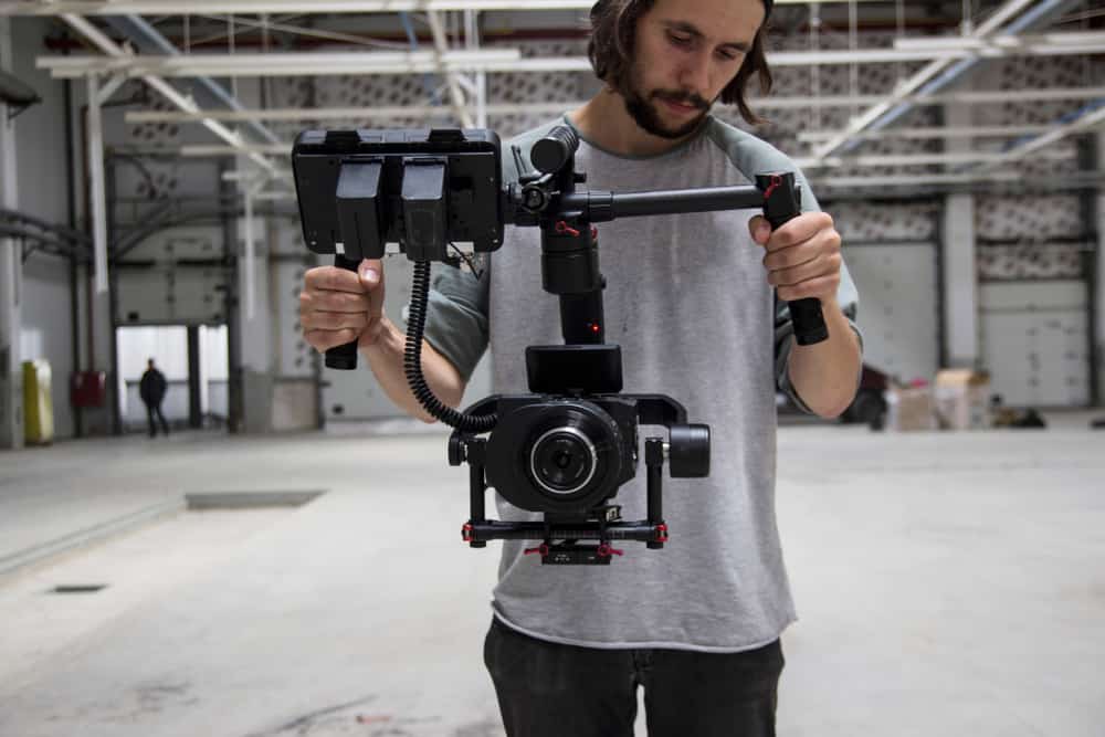 Cameraman looking at his rig on empty soundstage