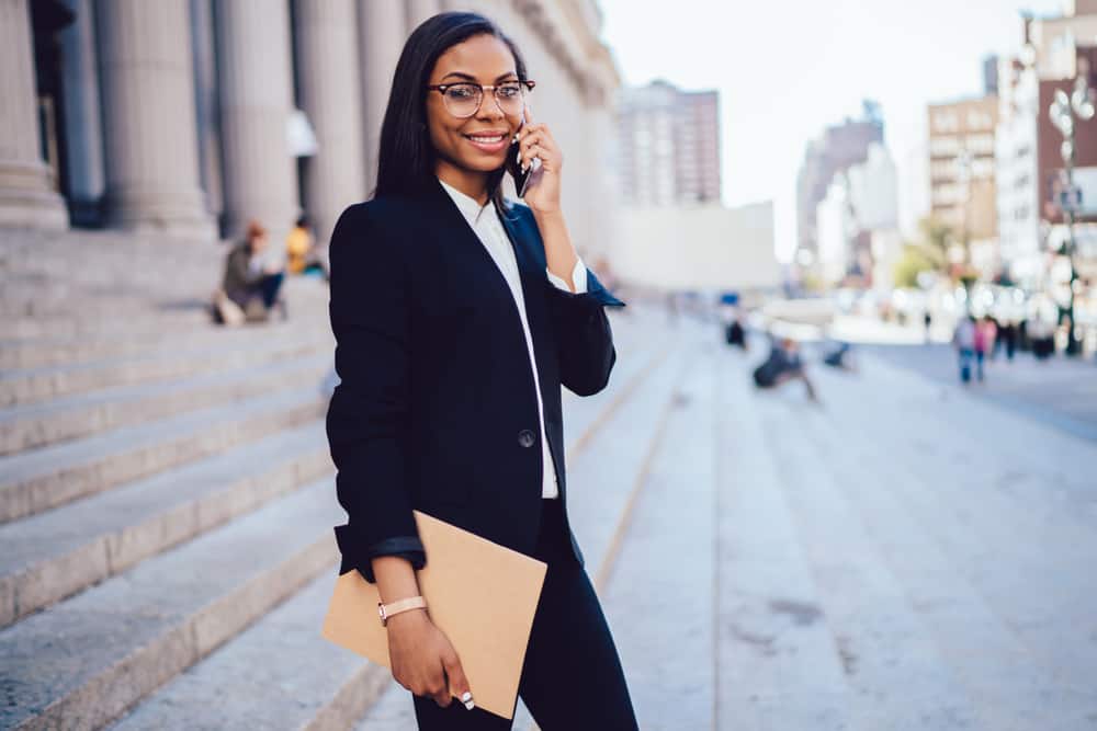 Female Entertainment Lawyer holding manila folder and walking outside