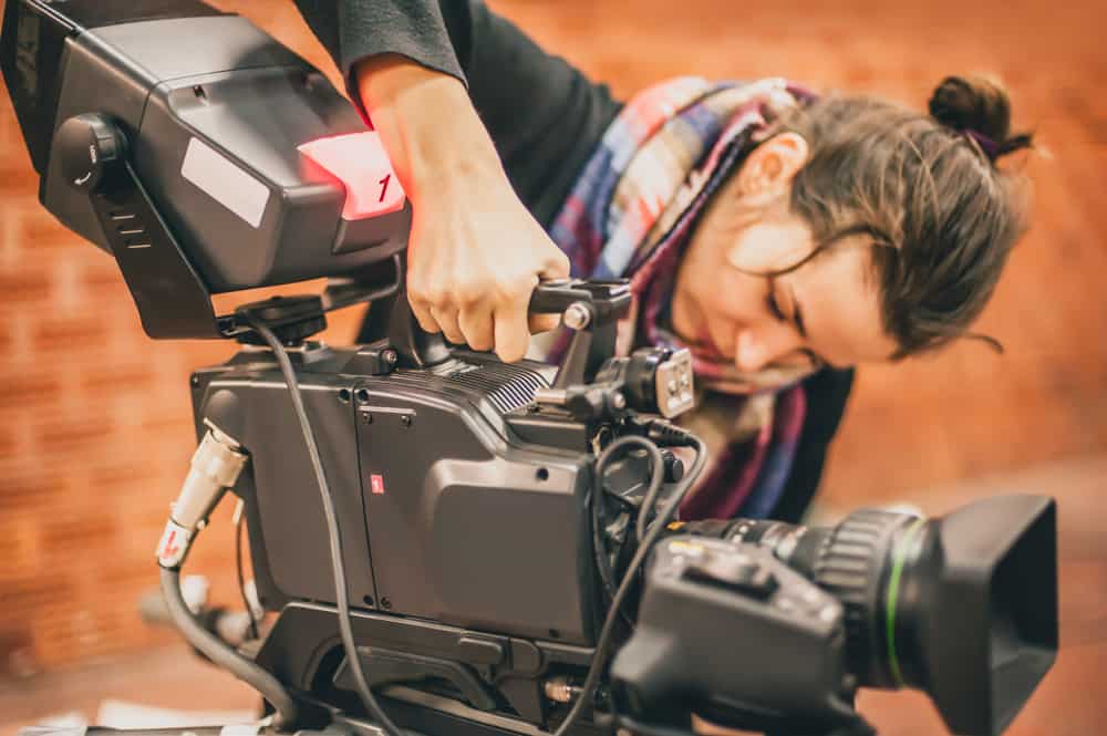 Female camera operator using camera on set during principal photography