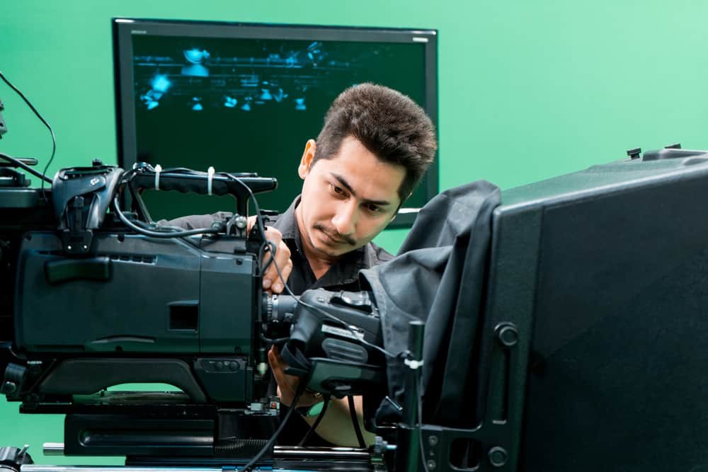 Visual Effects Supervisor looking at a camera on a set with a green screen