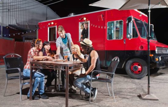 Key craft services team member serving lunch to film crew from a food truck