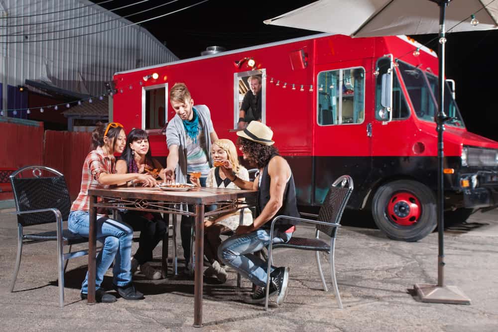 Key craft services team member serving lunch to film crew from a food truck