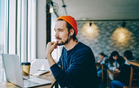 Screenwriter using the script template on his laptop in a cafe