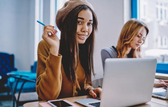 Young female screenwriter writing screenplay on her laptop