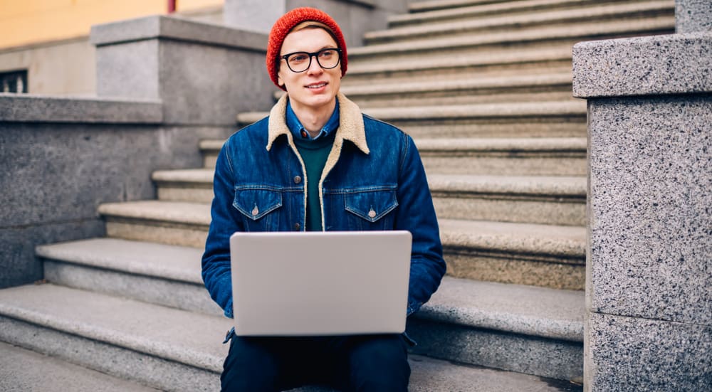 Screenwriter writing a movie script on his laptop outdoors