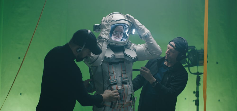VFX team with actor dressed as an astronaut in front of a green screen