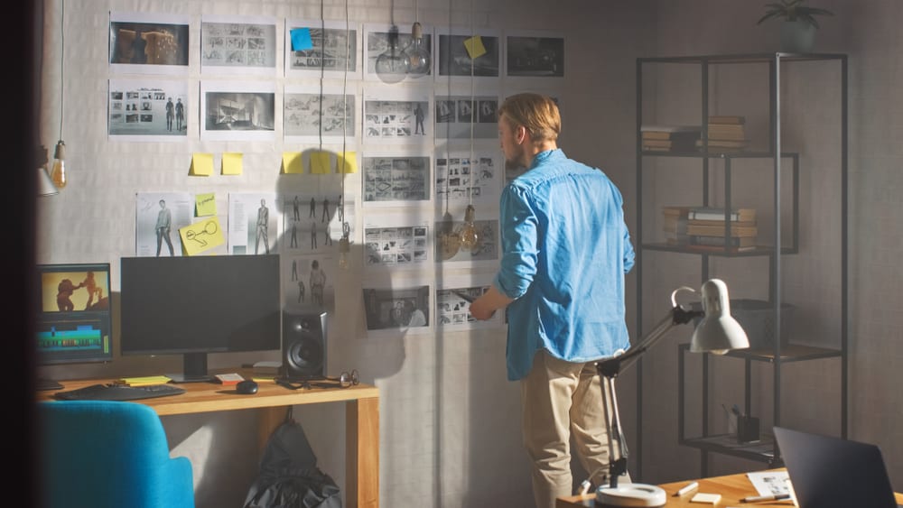 Storyboard artist looking at storyboarding panels on the wall