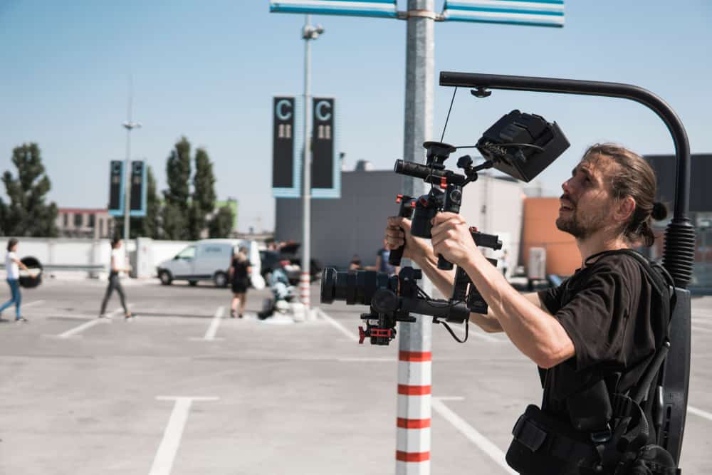 Male filmmaker with rig filming in a parking lot