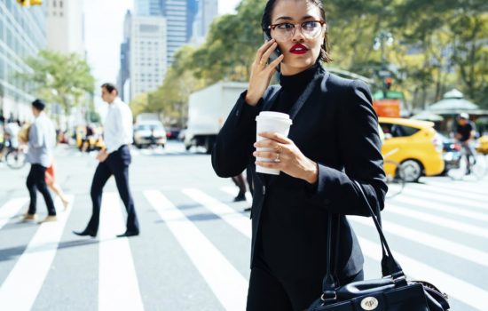 Female executive producer making a deal on her cell phone as she walks through the city
