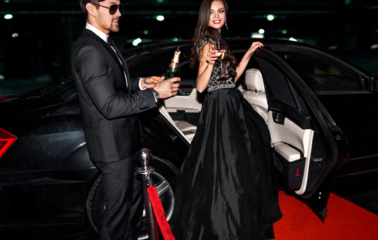 Male and female Actors getting out of limo on the red carpet