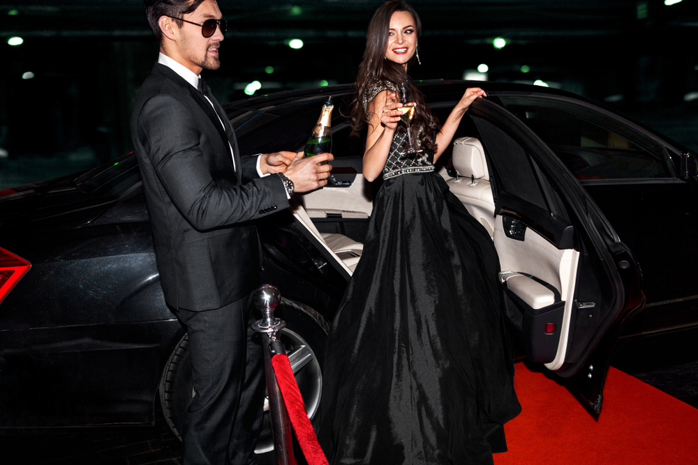 Male and female Actors getting out of limo on the red carpet